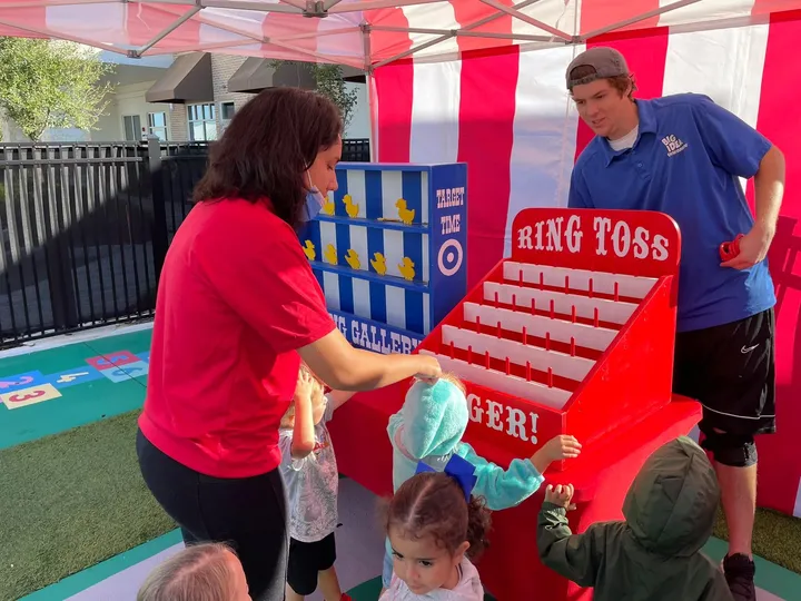 Hosts running carnival games for guests