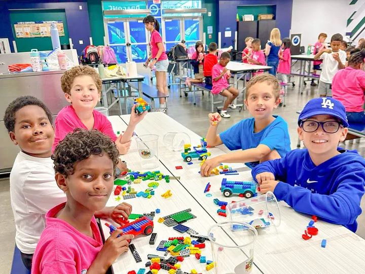 Kids build with bricks at a long party table
